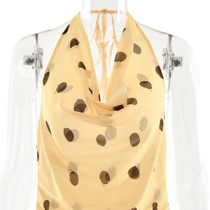 Detail view of beige polka dot halter neck dress with elegant cowl neckline and satin finish