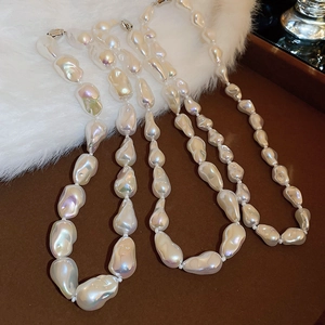 Detailed view of layered baroque pearls with natural luster on a soft plush background
