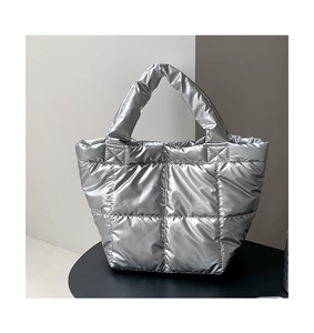 Detail of silver quilted down tote bag with metallic gloss finish and padded texture