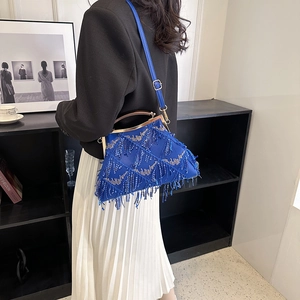Detail of blue rhinestone tassel handbag with metallic clasp and leather shoulder strap