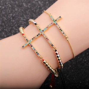 Ensemble de bracelets croix dorés avec zircons colorés portés par un mannequin