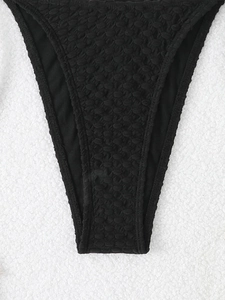 Close-up of black bikini bottom featuring unique 3D popcorn texture and elastic fabric