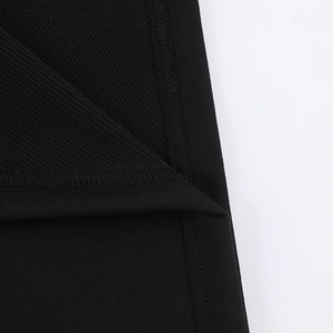 Close-up of the black knit fabric texture and high-quality stitching on the sweatshirt
