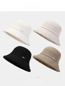 Détail de chapeaux bobs pliables en quatre couleurs avec logos métalliques dorés