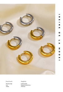 Detailed view of 4mm gold and silver polished huggie earrings on beige silk fabric