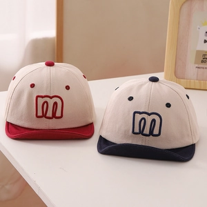 Detailed view of color-block baby baseball caps with embroidered letter M on the front