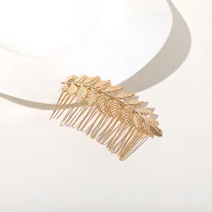 Detailed view of golden metal olive leaf bridal hair comb with fine engraved textures