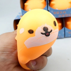 Close-up of hand squeezing orange Shiba Inu squishy toy showing texture and deformation