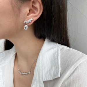 Close-up of elegant S925 silver bow earrings and necklace set with pear-shaped zircon stones