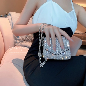 Close-up of sparkling silver rhinestone mini flap bag with metallic chain strap