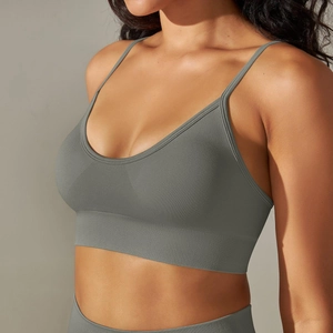 Close-up of seamless dark grey yoga bra showing ribbed hem and knit texture on model