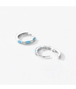 Detailed macro shot of S925 silver hoop earrings with blue enamel and sparkling cubic zirconia