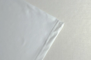 Close-up of double-stitched hem and white fabric texture on this elegant long dress
