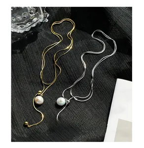 Detail of gold and silver adjustable long snake chain necklaces with baroque pearls