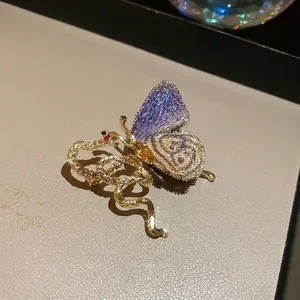 Exquisite gold butterfly brooch with purple lace wings and snake motif design