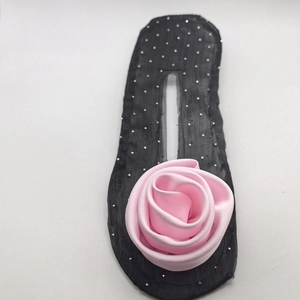 Detail of pink fabric rose and silver studded hair bun maker on a white background