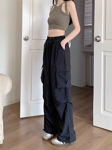 Side view of black loose cargo pants featuring large pockets and adjustable drawstring waist