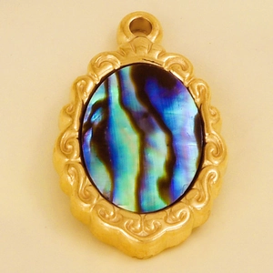 Close-up of vintage golden stainless steel pendant with iridescent abalone shell inlay