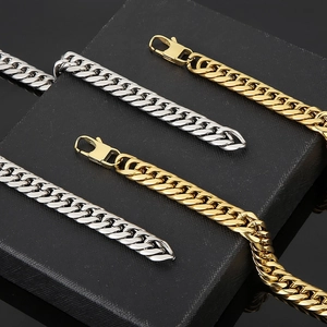 Close-up of gold and silver stainless steel Cuban link chains on a black jewelry box
