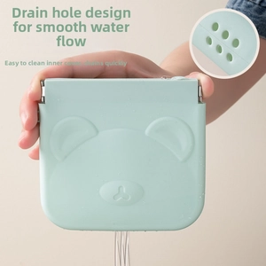 Close-up of mint green silicone pouch with bear relief and bottom drainage holes