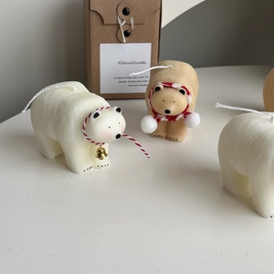 Detail of polar bear candles with festive scarves, bells and gift packaging box
