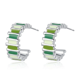 Minimalist C-shaped silver-plated earrings with green enamel stripes on white background