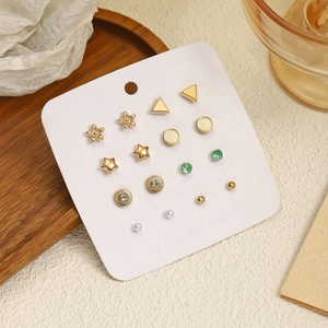 Détail de neuf paires de boucles d'oreilles dorées avec perles et étoiles sur carte