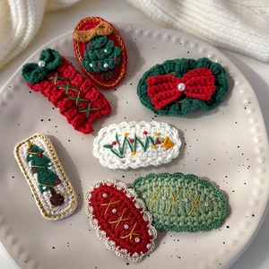 Detailed close-up of handmade crochet Christmas hair clips with festive tree patterns