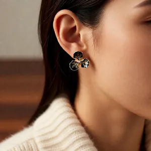 Boucles d'oreilles fleurs en émail noir vintage avec bords dorés et diamant rétro