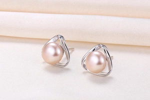 Macro shot of geometric silver triangle earrings with pink freshwater pearls