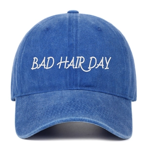 Détail de la broderie blanche Bad Hair Day sur la casquette en denim bleu délavé