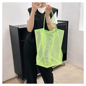 Dettaglio della borsa tote in mesh verde neon che mostra il materiale traspirante
