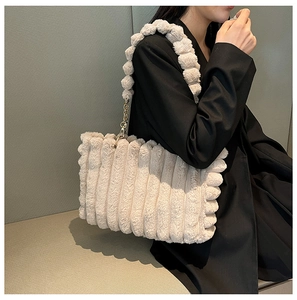 Detail of cream plush tote bag with gold chain strap and textured faux fur fabric