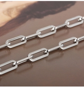 Detail of silver rectangular link chain showing polished metal texture and geometric structure