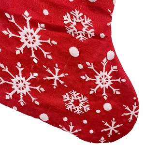 Close-up of a red knitted Christmas stocking featuring white snowflake and dot patterns