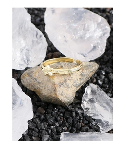 Detailed close-up of a gold hammered star ring displayed on natural crystal and raw stone