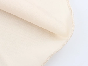 Macro shot of beige knitted fabric with high-quality overlock stitching detail
