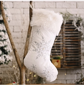 Close-up of white velvet Christmas stocking with pearl snowflakes and faux fur trim