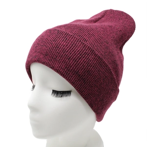 Close-up of wine red ribbed knit beanie showing dense texture and folded cuff detail
