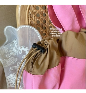 Dettaglio ravvicinato della borsa a secchiello in nylon rosa e kaki con coulisse regolabile