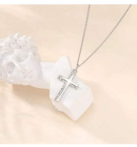 Macro detail of silver cross pendant with micro zircon stones on a white statue