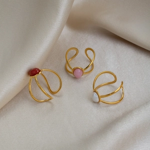 Three vintage 18K gold-plated stainless steel rings with oval natural gemstones on satin