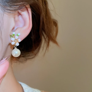 Nahaufnahme von 18k vergoldeten Blumenohrringen mit Zirkonia und hängenden Perlen