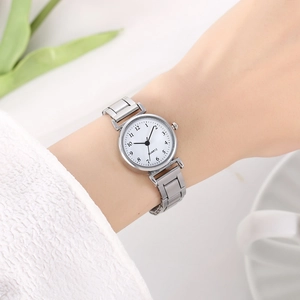 Minimalist silver chain quartz watch with a white round dial on a woman's wrist
