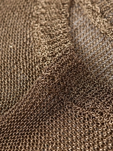 Vue macro d'un tricot métallique montrant la texture détaillée de la maille bronze