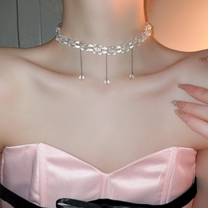 Close-up of sparkling clear glass beaded choker necklace with silver metallic tassels