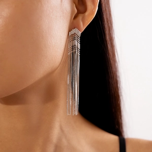 Detail of silver long fringe tassel earrings on a model showing metallic arrow design