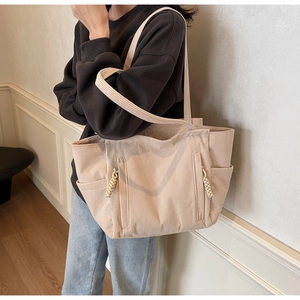 Dettaglio della borsa tote in velluto a coste beige con texture e tasca laterale