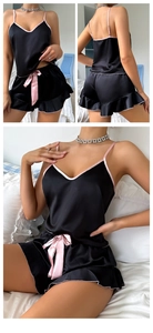 Détail de l'ensemble pyjama en satin noir avec liseré rose et nœud en ruban doux