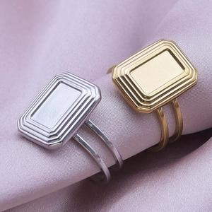 Minimalist rectangular tiered rings in gold and silver finish on purple silk fabric